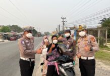 Polantas Polres Rohil Bagi Masker ke Pengendara, Ingatkan Bahaya Karhutla